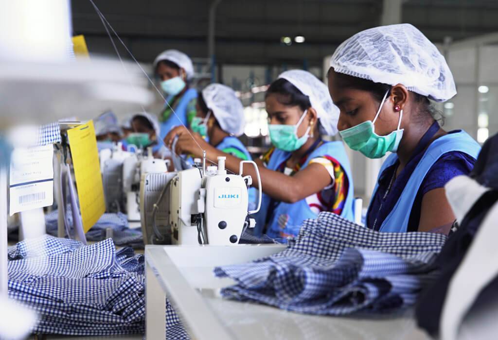 Several women sewing clothes in a factory