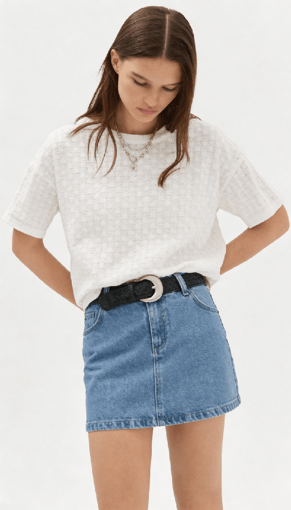 Woman wearing a knitted top paired with a denim skirt showcasing knitwear apparel design